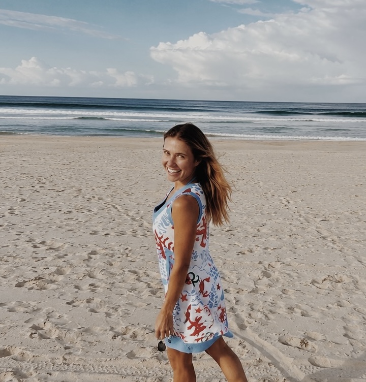 Heather smiling on a quiet beach, ocean behind her